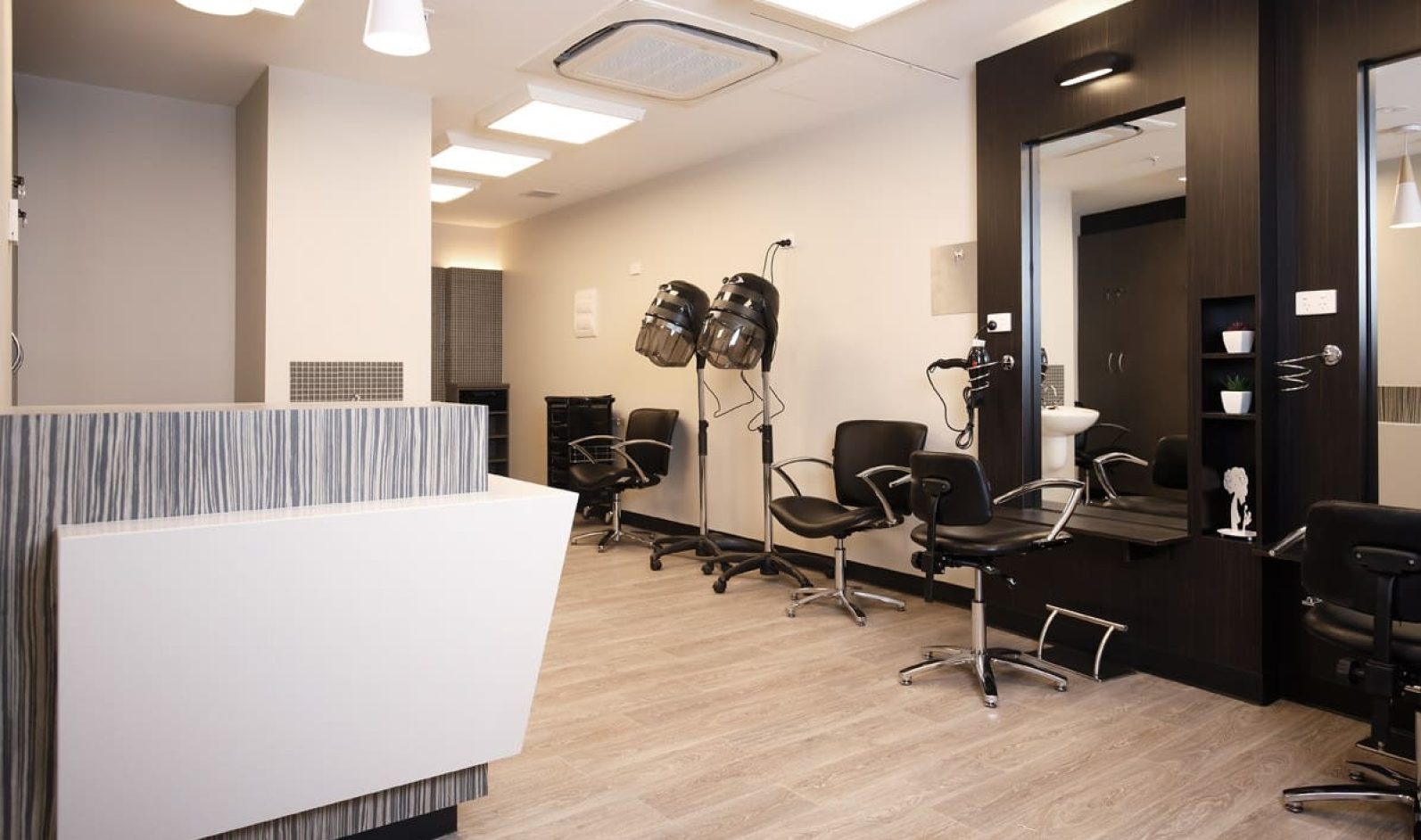 Hair salon with front desk and salon chairs pictured.