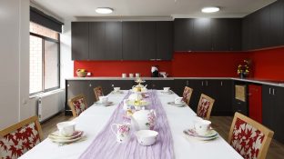 A set dining table with kitchen visible in the background