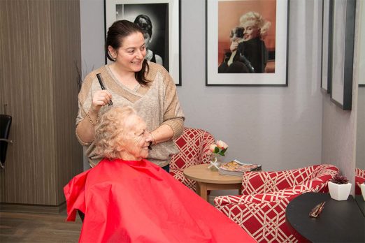 Resident and hairdresser looking into the salon mirror