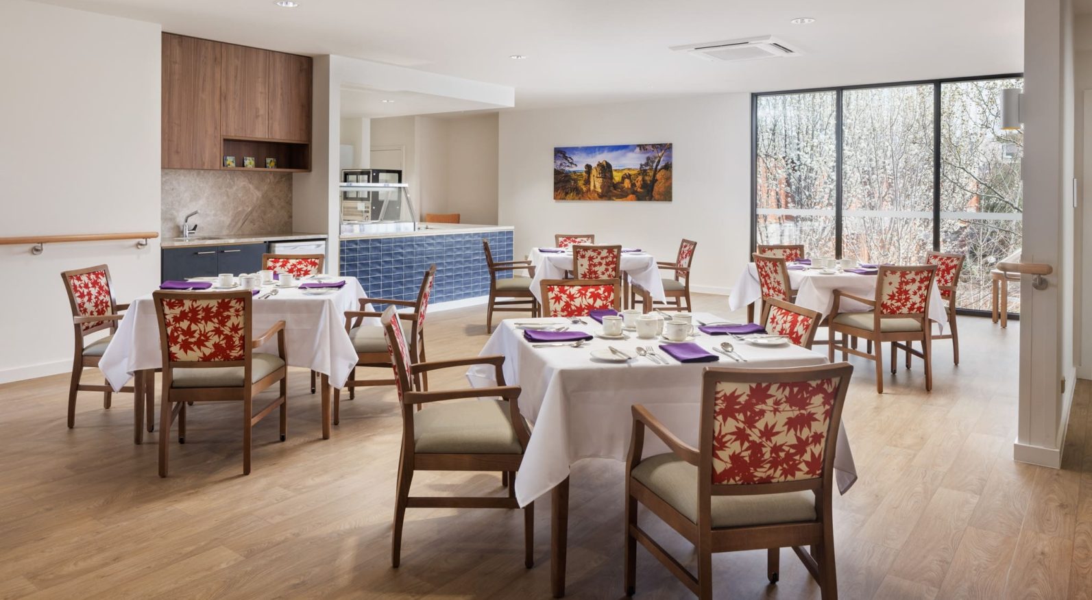 The dining area is captured with dining tables and a kitchen area.