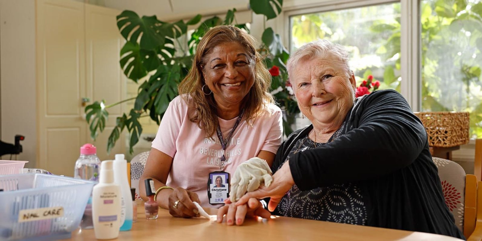 Two people pictured smiling sitting next to eachother at table.